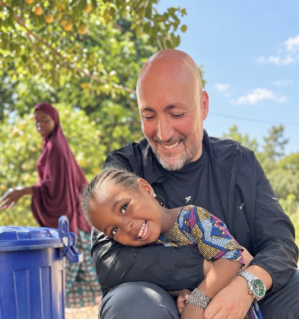 Membres du Collectif Humaniterre avec un enfant, devant un arbre fruitier.